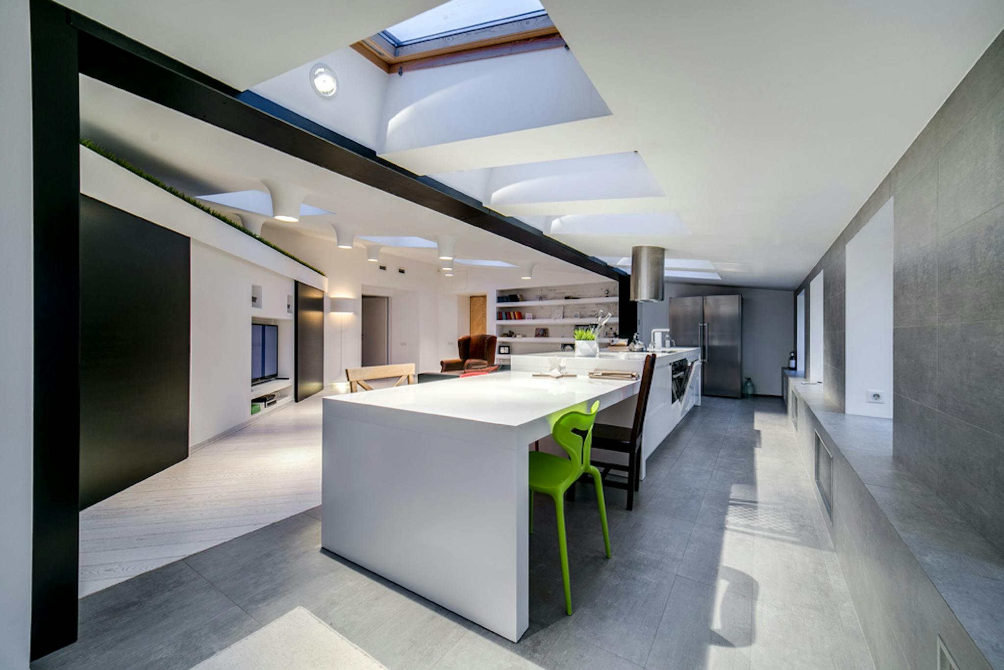 Sleek open-concept kitchen with modern and minimalist design elements and skylights.